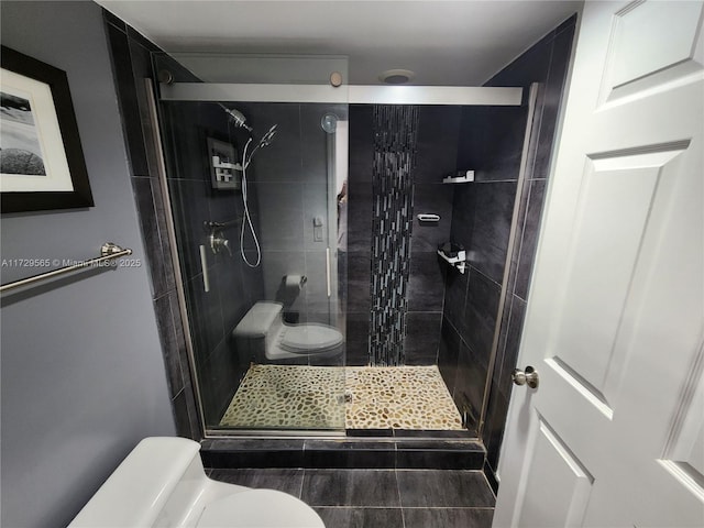 bathroom with toilet and a shower with door