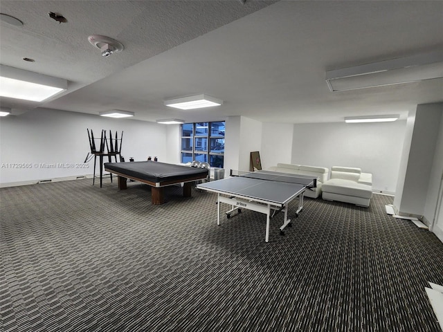 recreation room featuring a textured ceiling, pool table, and dark colored carpet