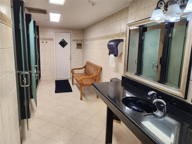 bathroom featuring sink, tile walls, walk in shower, and tile patterned flooring