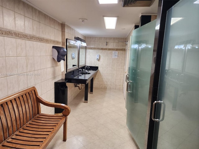 bathroom featuring ornamental molding, tile patterned flooring, walk in shower, and tile walls