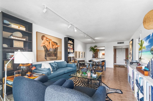 tiled living room with a textured ceiling and built in features