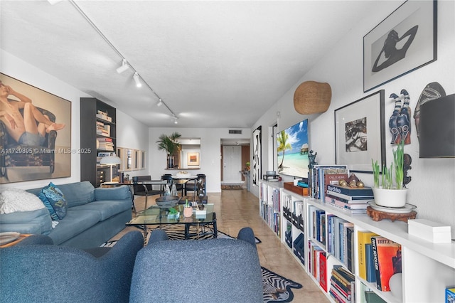 living room with track lighting, tile patterned floors, and a textured ceiling