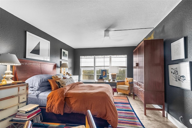 tiled bedroom with ceiling fan and a textured ceiling