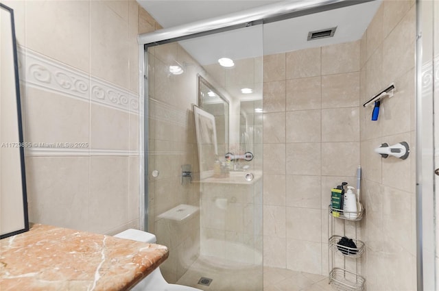 bathroom featuring a shower with door and vanity