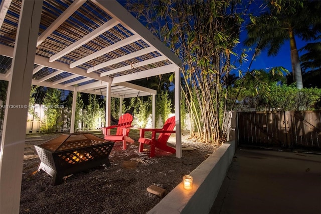 patio at twilight featuring an outdoor fire pit and a pergola