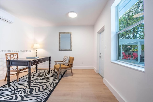 office space featuring light wood-type flooring and a wall mounted AC