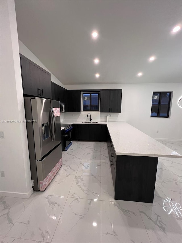 kitchen featuring sink, kitchen peninsula, stainless steel appliances, and vaulted ceiling