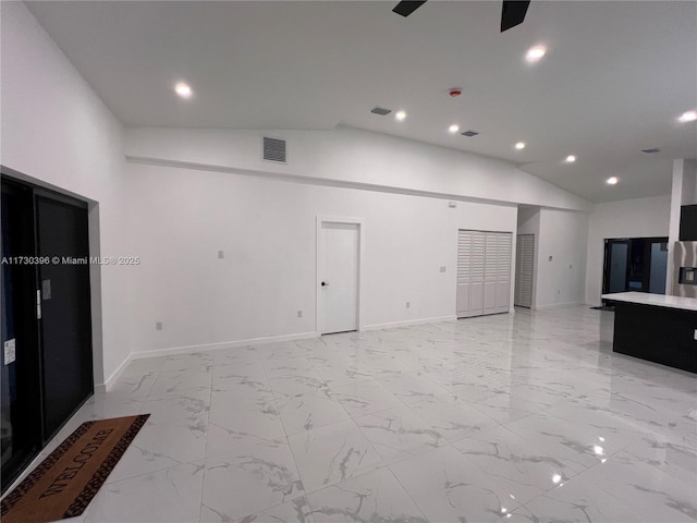 unfurnished living room with ceiling fan and high vaulted ceiling