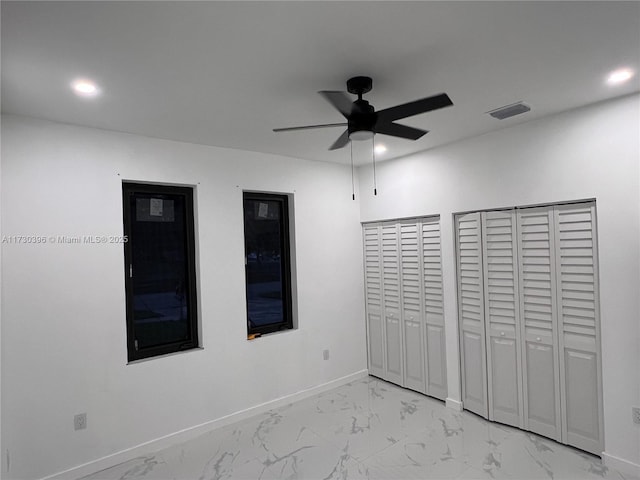 unfurnished bedroom with two closets and ceiling fan