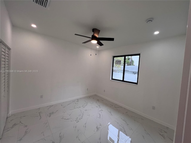 empty room with marble finish floor, baseboards, visible vents, and recessed lighting