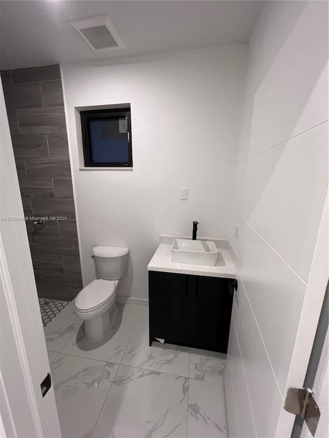 bathroom with toilet, walk in shower, and vanity