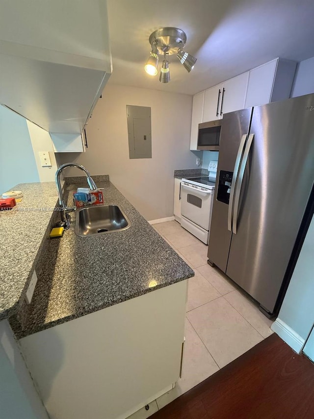 kitchen with white cabinets, kitchen peninsula, appliances with stainless steel finishes, and sink