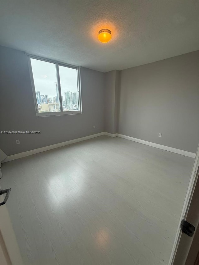 unfurnished room featuring a textured ceiling