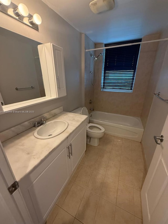 full bathroom with tile patterned floors, tiled shower / bath combo, vanity, and toilet