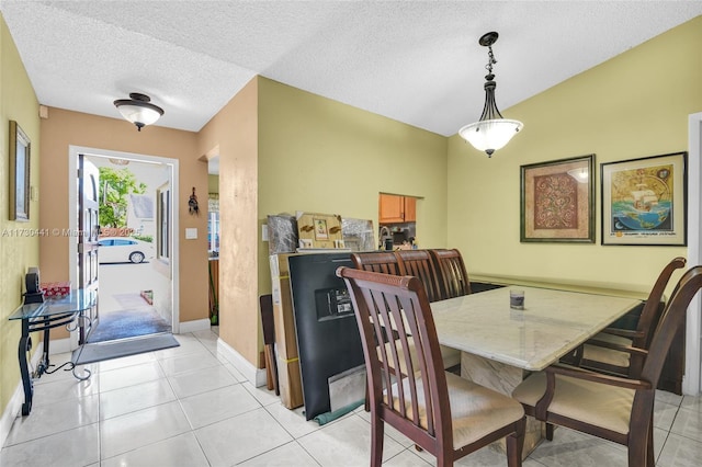 dining room featuring a textured ceiling and light tile patterned floors