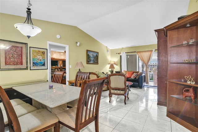 dining room featuring light tile patterned floors and vaulted ceiling