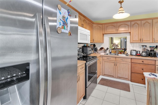 kitchen with hanging light fixtures, sink, tasteful backsplash, light tile patterned flooring, and stainless steel appliances