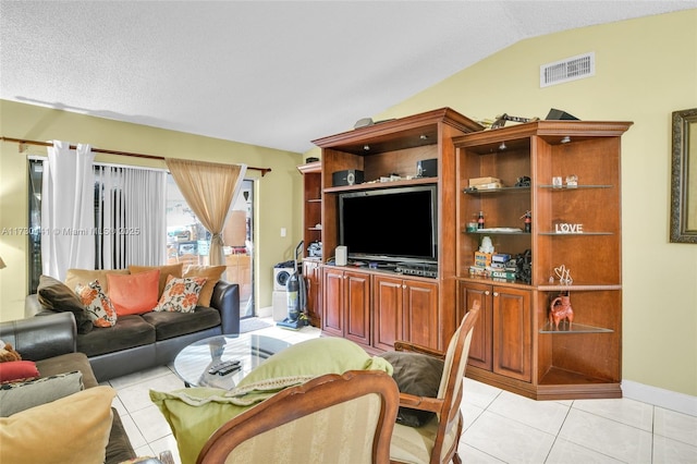 living room featuring vaulted ceiling and light tile patterned floors