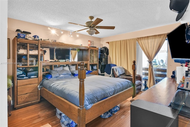 bedroom with ceiling fan, a textured ceiling, and hardwood / wood-style flooring