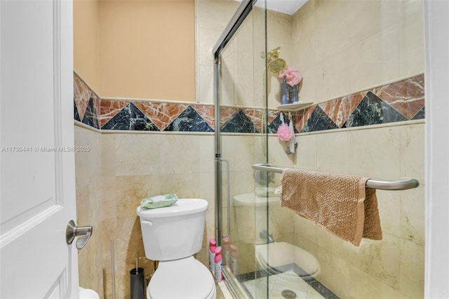 bathroom with toilet, tile walls, and an enclosed shower