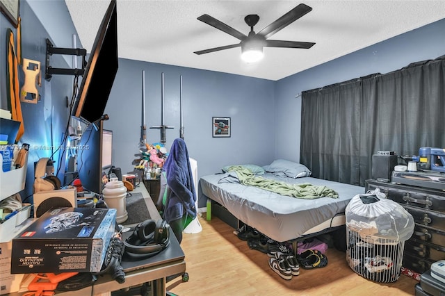 bedroom featuring ceiling fan, a textured ceiling, and light wood-type flooring