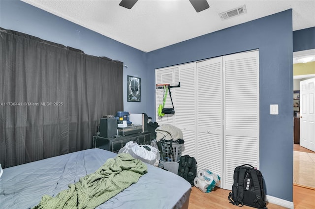 bedroom with ceiling fan, hardwood / wood-style floors, and a closet