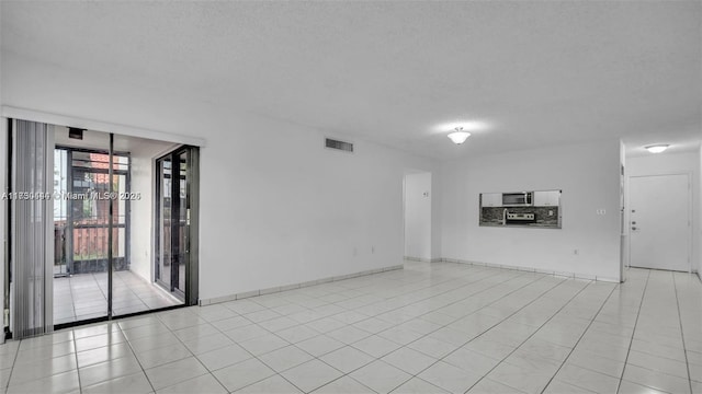 460 W Park Dr Unit 207, Miami, FL 33172 - empty room featuring light tile patterned floors, a textured ceiling, baseboards, and visible vents