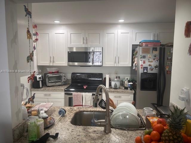 460 W Park Dr Unit 207, Miami, FL 33172 - kitchen with white cabinets, stainless steel appliances, and a toaster