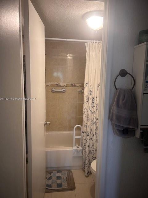 bathroom featuring tile patterned flooring, shower / tub combo with curtain, a textured ceiling, and toilet