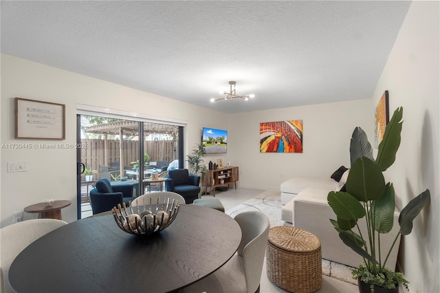 dining room featuring a textured ceiling, baseboards, and a notable chandelier