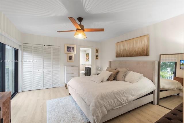 bedroom featuring ensuite bathroom, light wood finished floors, and a ceiling fan