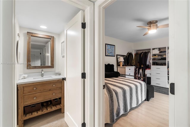 bedroom with recessed lighting, a closet, a sink, ceiling fan, and light wood-type flooring