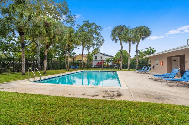 pool with a yard, fence, and a patio