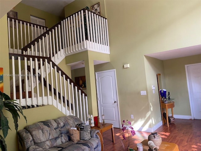 living room featuring a high ceiling and wood-type flooring