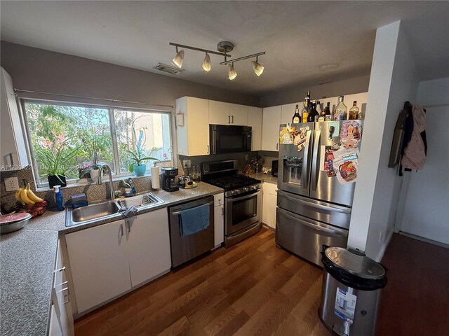 kitchen with white cabinets, dark wood-type flooring, stainless steel appliances, kitchen peninsula, and a breakfast bar area