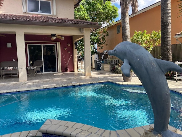 view of swimming pool with ceiling fan and a patio