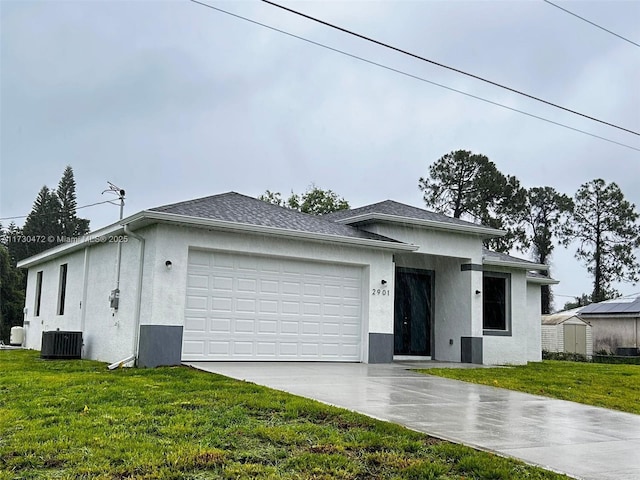 view of front of house featuring central AC, a garage, and a front lawn