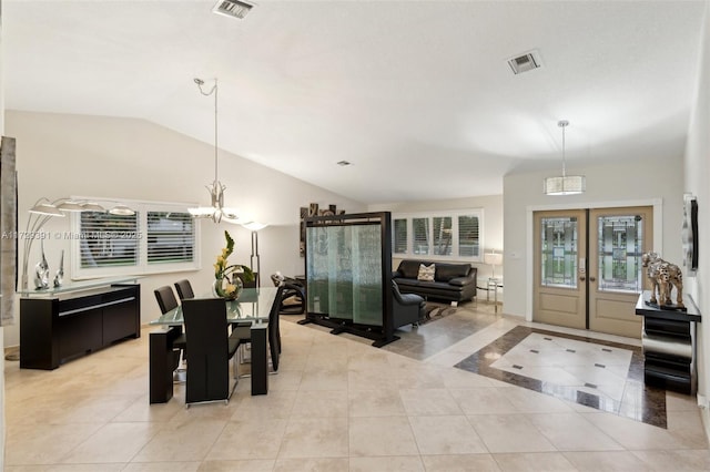 dining room with lofted ceiling, light tile patterned floors, a notable chandelier, and french doors