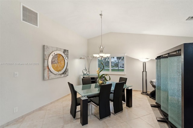 tiled dining room featuring a chandelier and vaulted ceiling