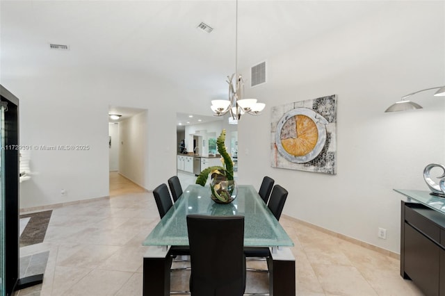 tiled dining area with a high ceiling and an inviting chandelier