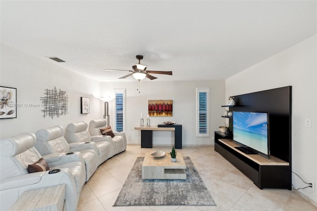 living room featuring ceiling fan, light tile patterned floors, and a textured ceiling