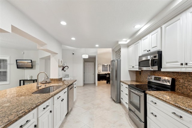 kitchen with sink, white cabinets, appliances with stainless steel finishes, and dark stone counters