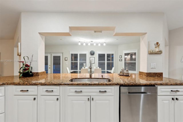 kitchen featuring sink, white cabinets, kitchen peninsula, and dark stone countertops