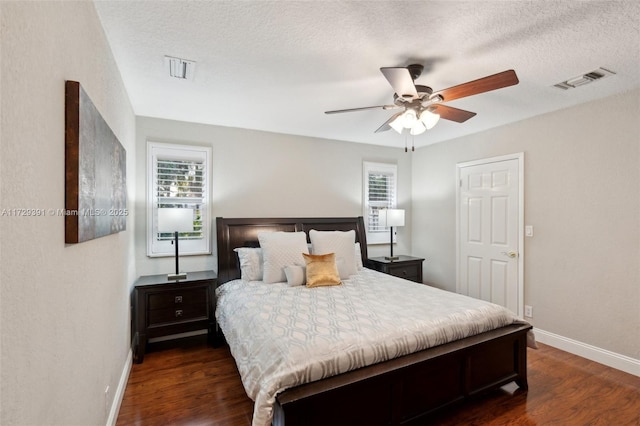 bedroom with multiple windows, ceiling fan, and dark hardwood / wood-style flooring