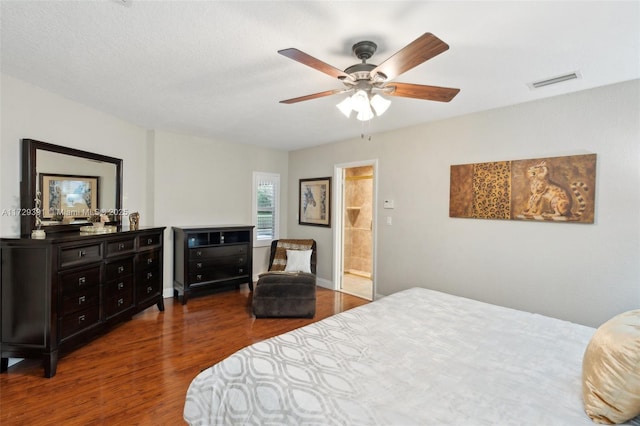 bedroom with ceiling fan, dark hardwood / wood-style floors, and ensuite bath