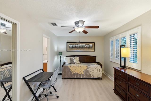 bedroom featuring light hardwood / wood-style floors, a textured ceiling, connected bathroom, and ceiling fan