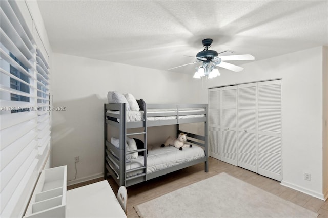 bedroom with wood-type flooring, a textured ceiling, a closet, and ceiling fan