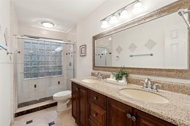 bathroom with toilet, a shower with shower door, tile patterned floors, and vanity