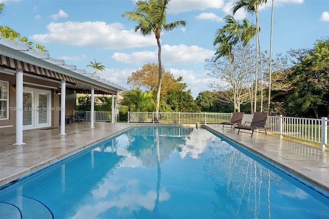 view of swimming pool with a patio and french doors