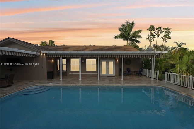 pool at dusk with a patio